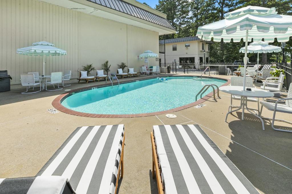 a large swimming pool with chairs and tables and umbrellas at Candlewick Inn and Suites in Eureka Springs