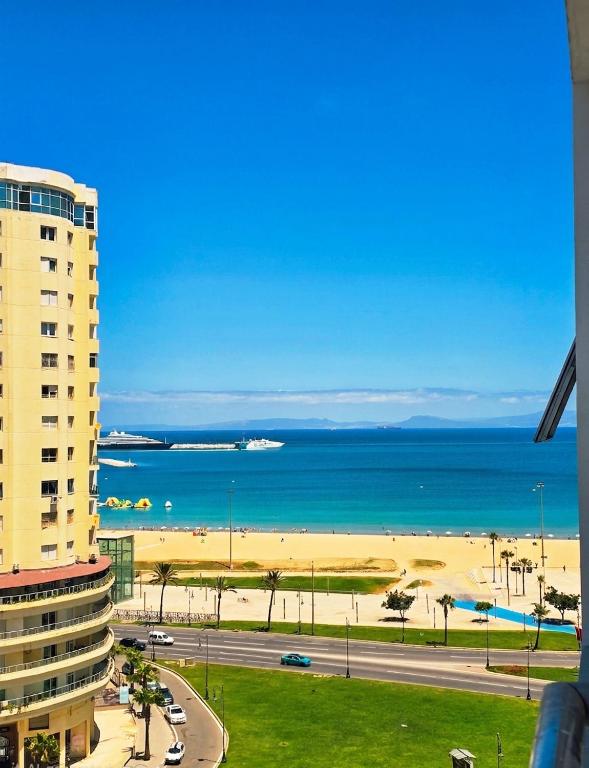 a view of a beach with a building and the ocean at panoramic sky 17 in Tangier