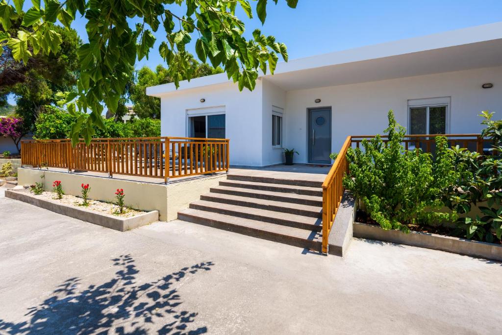 a house with a wooden railing and stairs at Polytimi Summerhouse in Ialysos