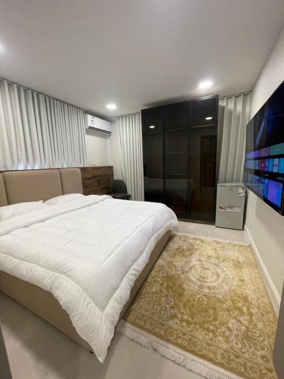 a bedroom with a large bed and a flat screen tv at سويتات الباديه in Dammam
