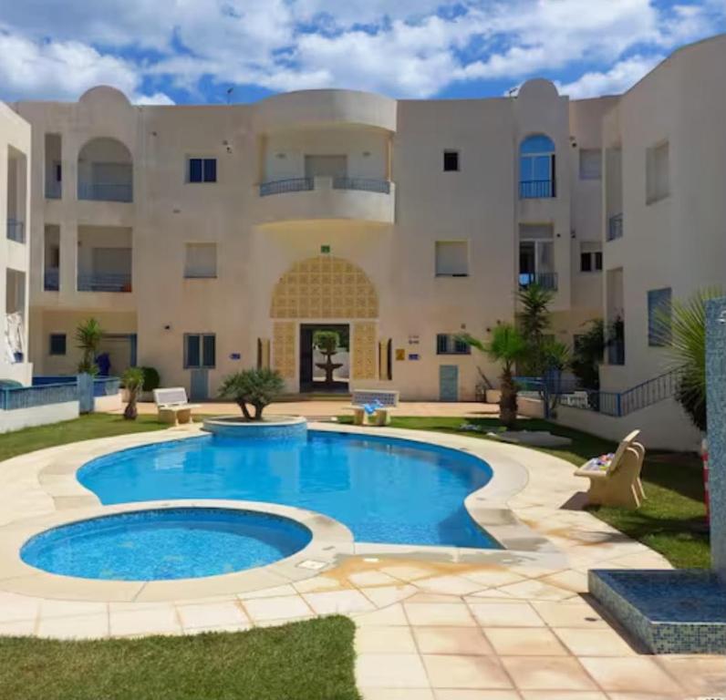 a swimming pool in front of a large building at Dar el Bahri in Beni Khiar