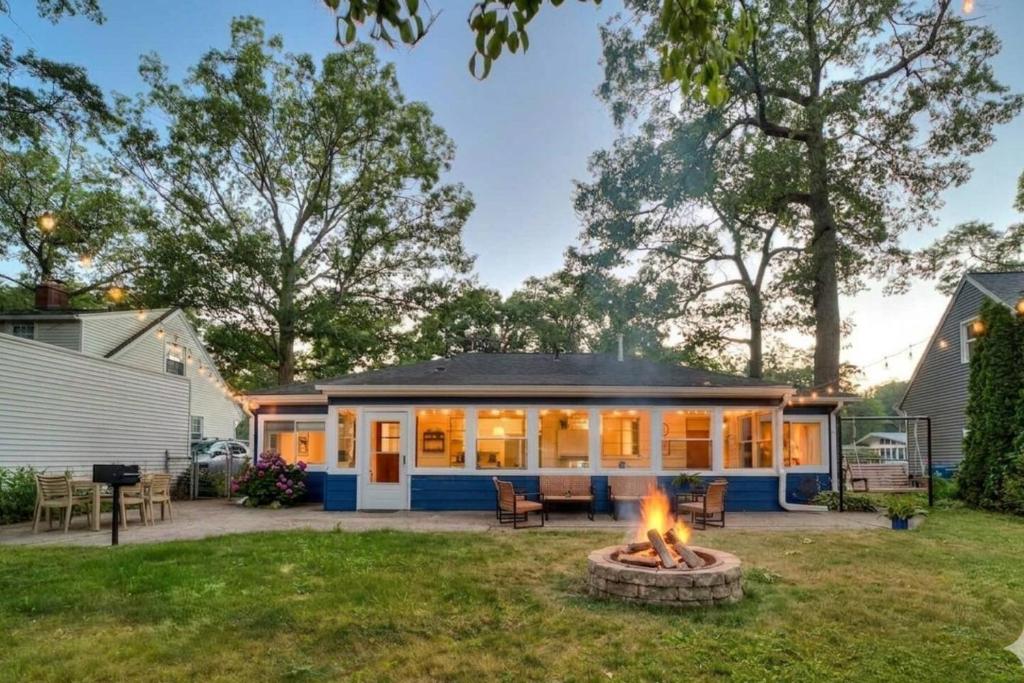 a house with a fire pit in the yard at Glenside Getaway in Muskegon