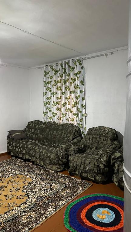 a living room with a couch and a rug at Vintage House Aisha in Kaji-Say