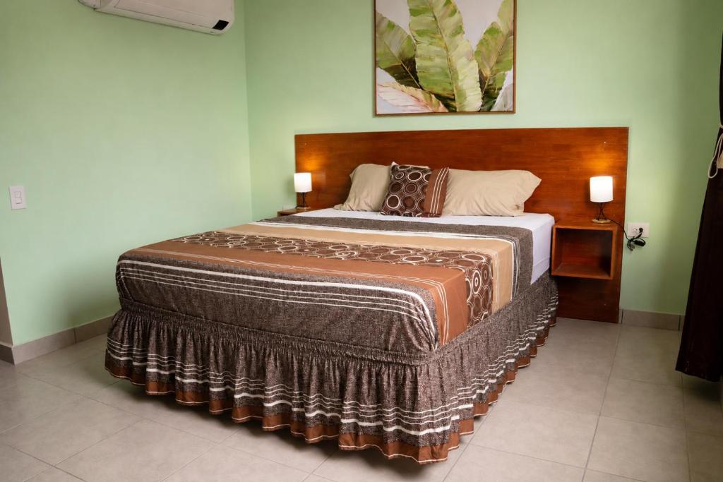 a bedroom with a large bed with a wooden headboard at Torogoz Home in San Salvador