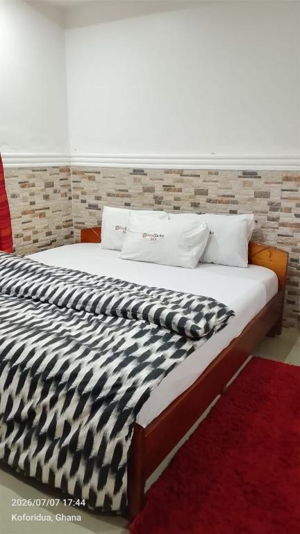a large bed with a black and white comforter at FREDJACKSAIR BNb in Koforidua