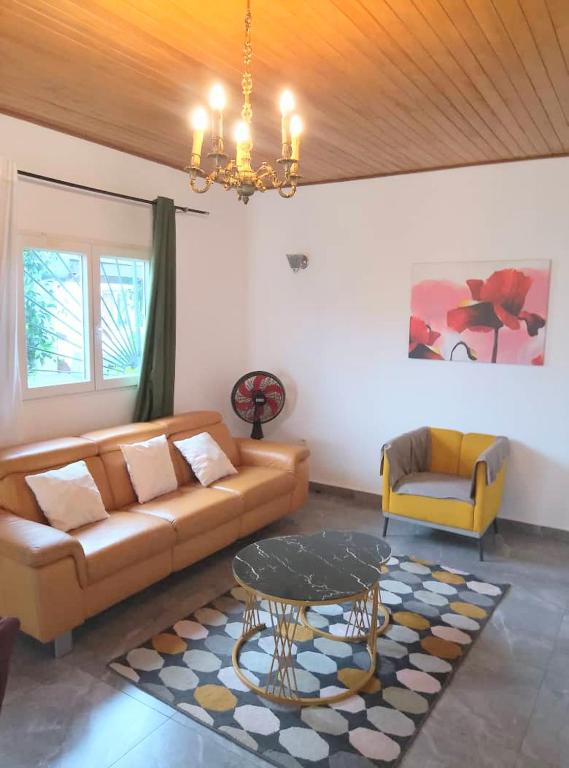 a living room with a couch and a table at Résidence Merveilles G06 in Kribi