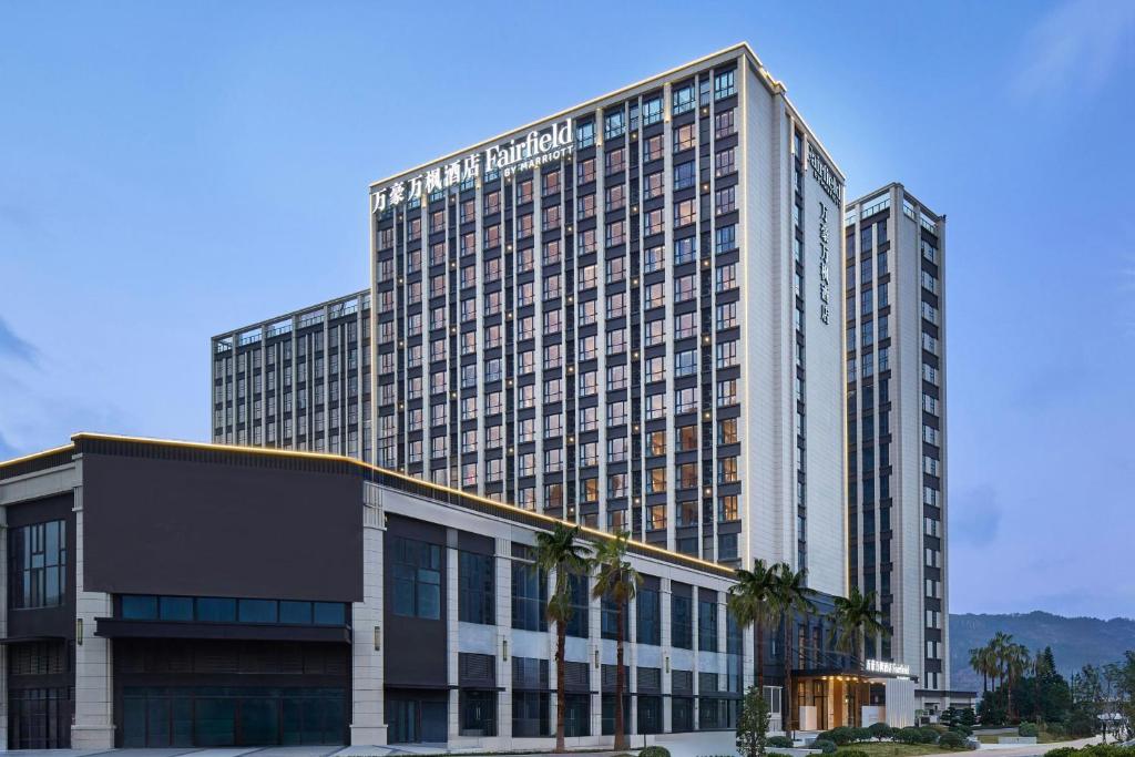 a tall building with palm trees in front of it at Fairfield by Marriott Ningde Xiapu in Xiapu