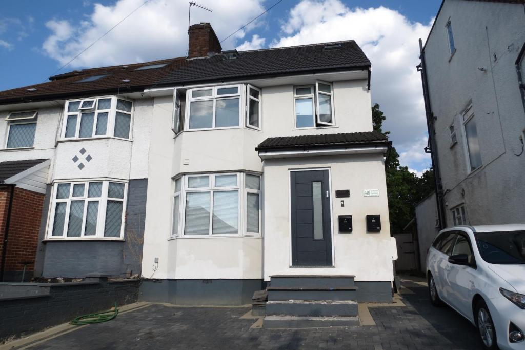 a white house with a car parked in front of it at Luxury Budget Flat in Middlesex in Colindale