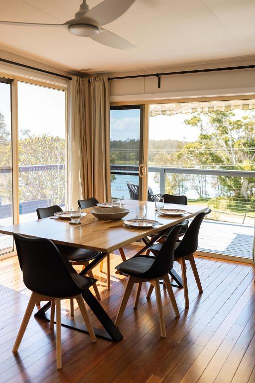 a dining room with a large wooden table and chairs at The Mullet in Nambucca Heads