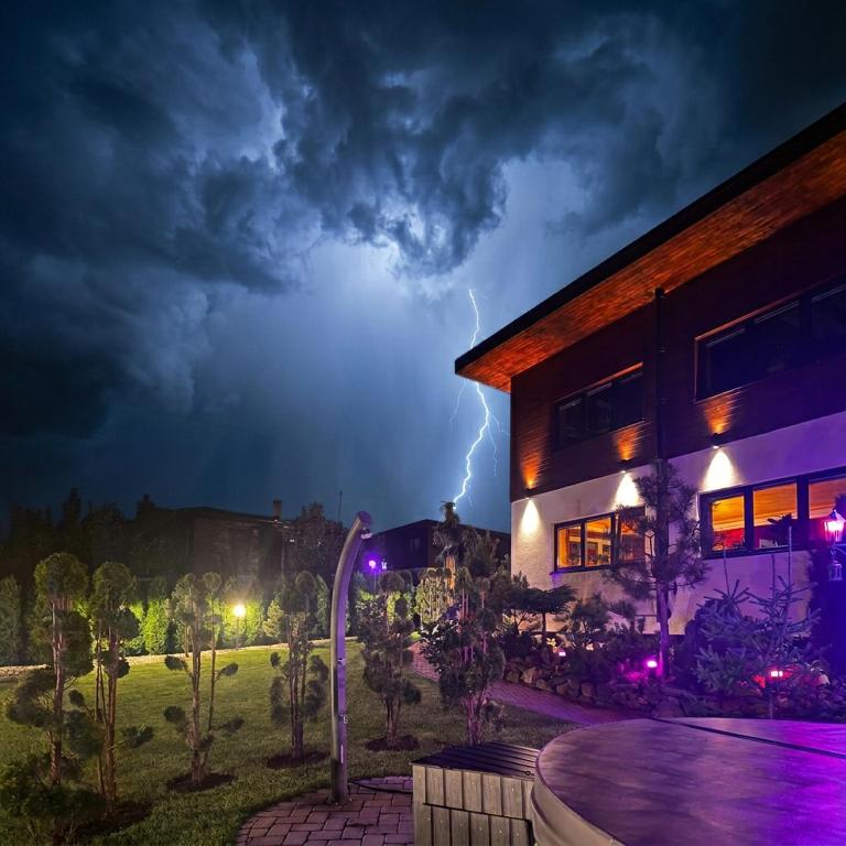 a lightning storm over a building with a building at Ostravice Apartment in Ostravice