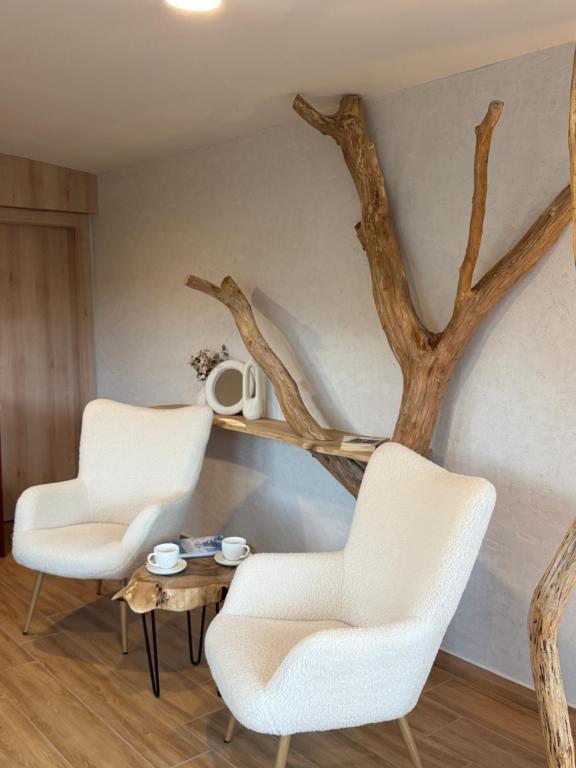 two chairs and a table with a tree on the wall at KUBIQ 2 Transalpina in Sebeş