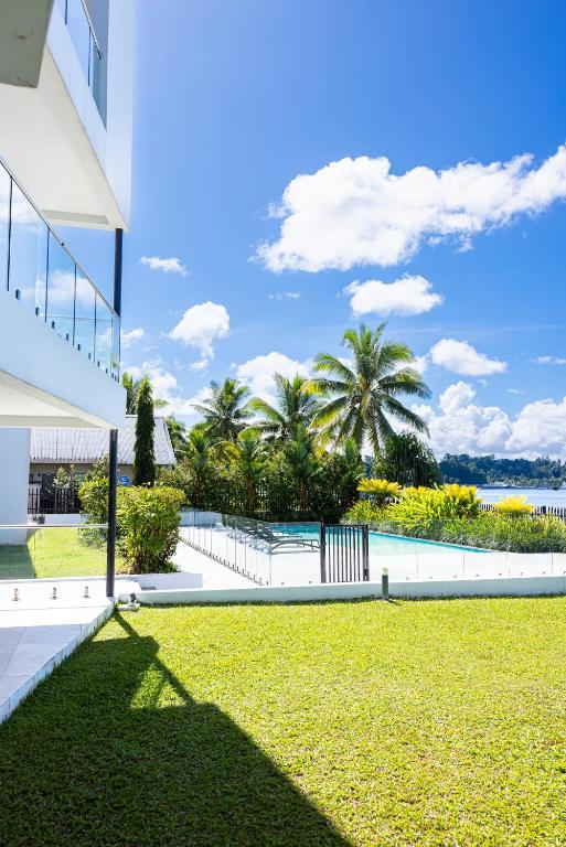 a view of a building and a lawn with palm trees at 104 - Suva City Views Oceanfront Backyard in Suva