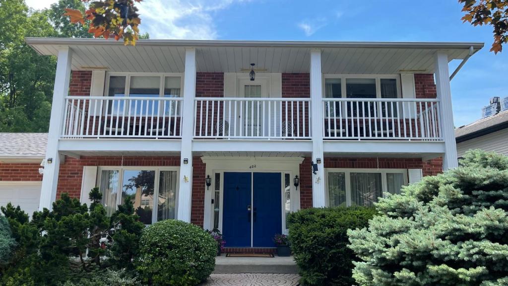 a house with a porch and a blue door at Bruce Manor in Niagara-on-the-Lake