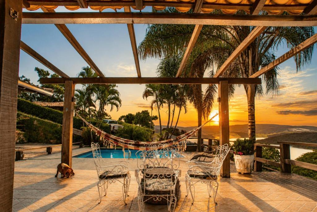 a patio with a table and chairs and a dog at Casa com Vista inigualável "Vista del Lago" in Capitólio