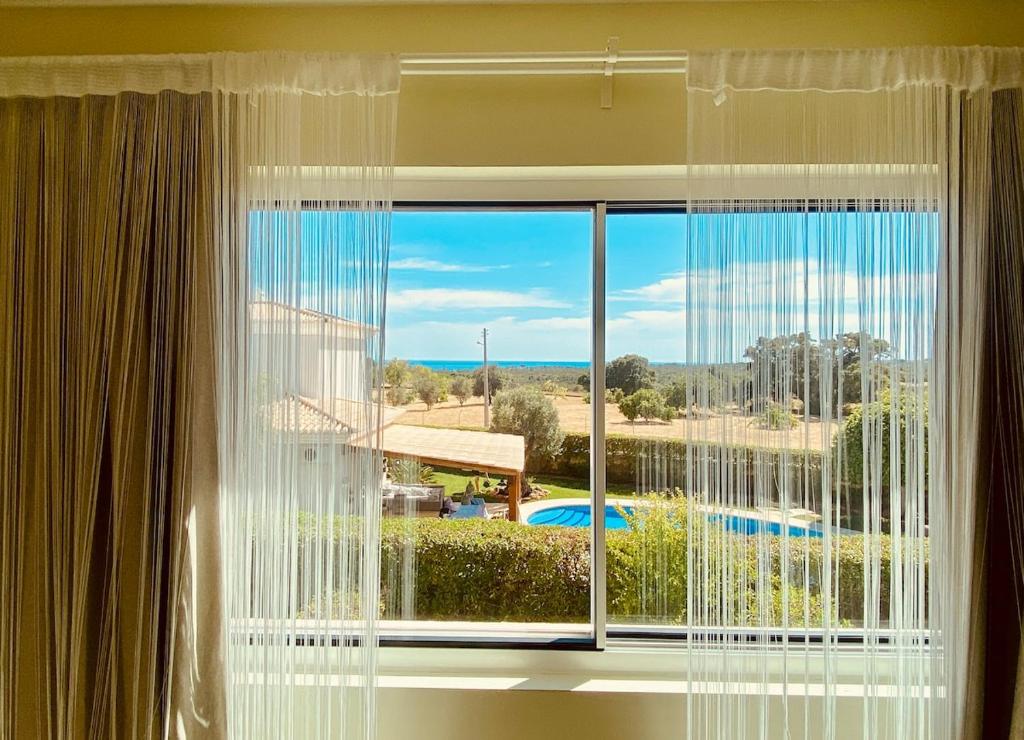 a window with a view of a pool at Senhora da Rocha Sea View, Pool, Terrace in Porches