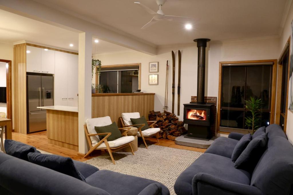 a living room with a blue couch and a fireplace at Alpine Digs in Jindabyne