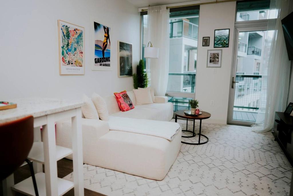 a living room with a white couch and a table at Luxury 2BR Apartment with Pool, Balcony & Parking in Cambridge