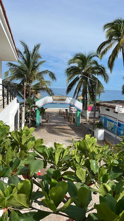 a view of a beach with palm trees and a bridge at Departamento in Lo de Marcos