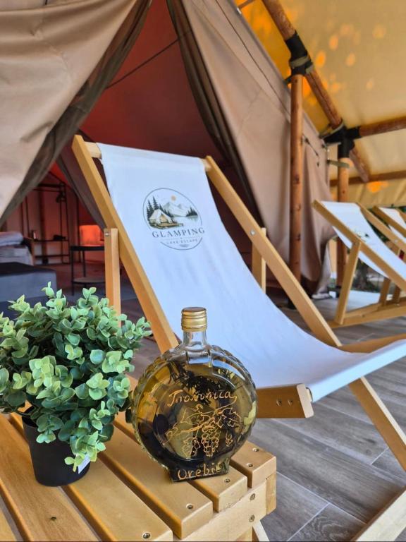 a glass bottle sitting on a table next to a tent at Glamping Lake Escape in Virpazar