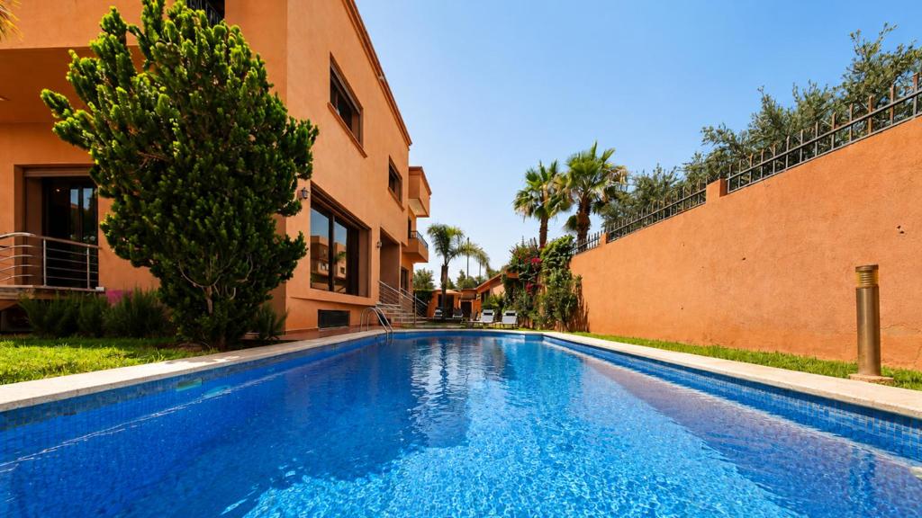 a swimming pool in front of a building at Villa Amroth in Marrakesh
