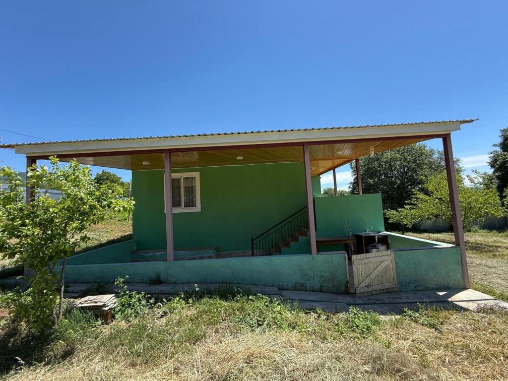 a small green house with a roof on a field at Relax in mountains in İsmayıllı