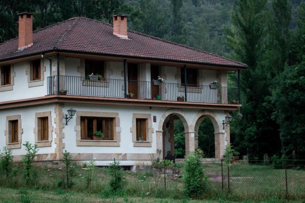 a large white house with a balcony on top at Los Jazmines de la Vega in La Vega