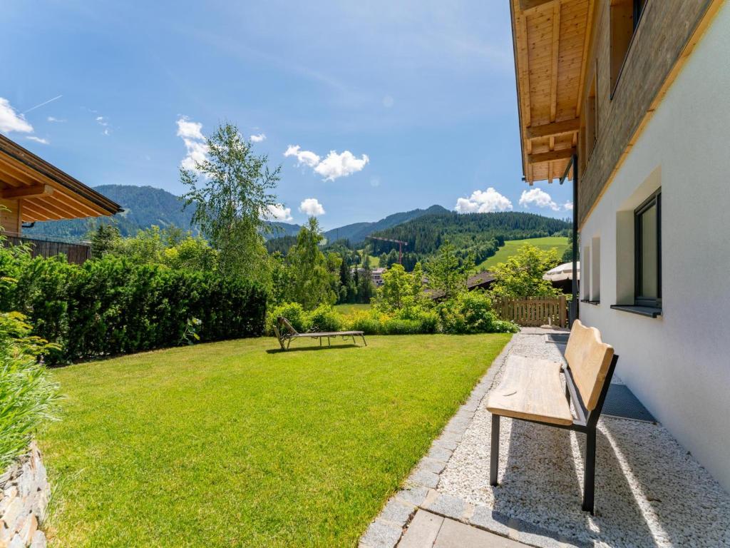 a garden with two benches and a grassy yard at Werfenblick in Werfenweng