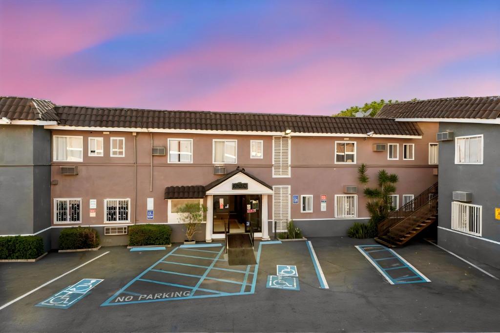 a large apartment building with a parking lot at Encore Inn Inglewood in Inglewood