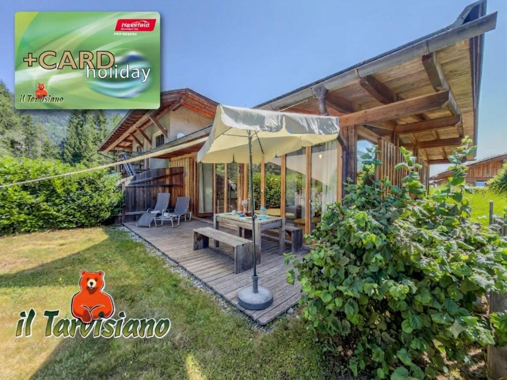 a house with a patio with an umbrella at See Chalet 50 in Lake Pressegg