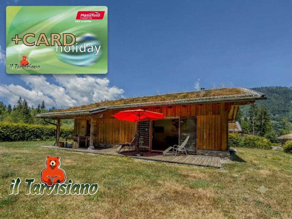 a small house with a red umbrella in a field at Oselitzen 56 in Lake Pressegg