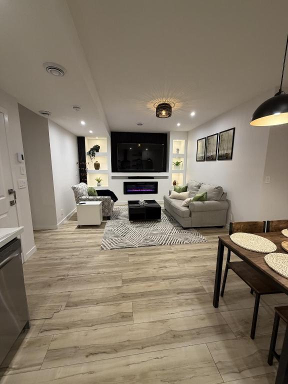a living room with a couch and a table and a tv at The Ogieva Suites in Airdrie