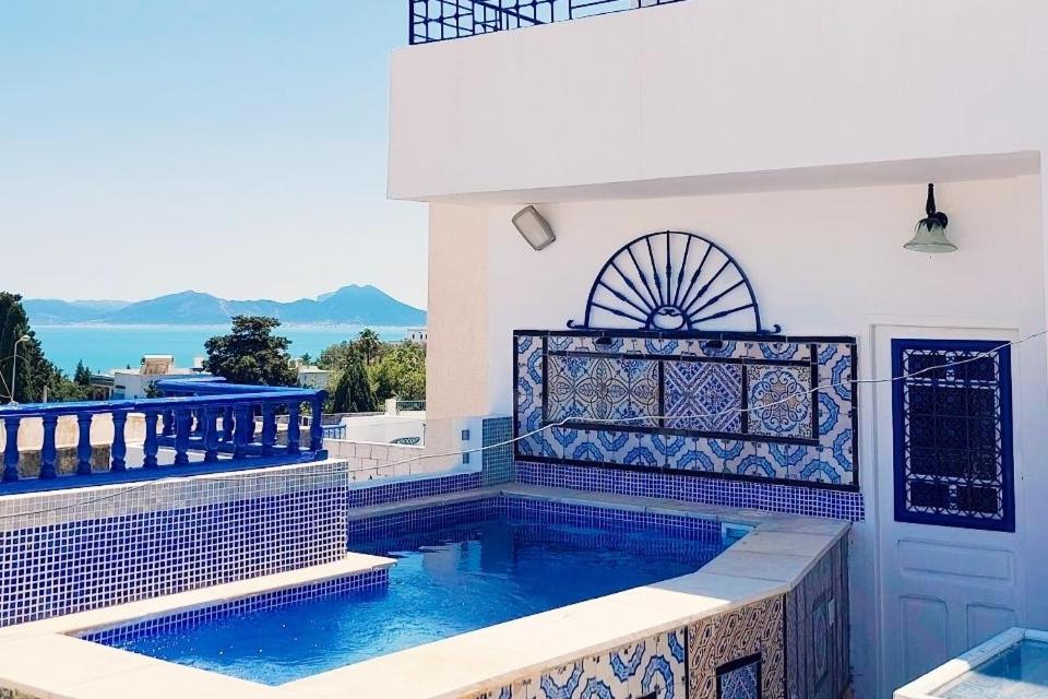 a swimming pool next to a white house at House Near the Sky in Dar Salah Bey