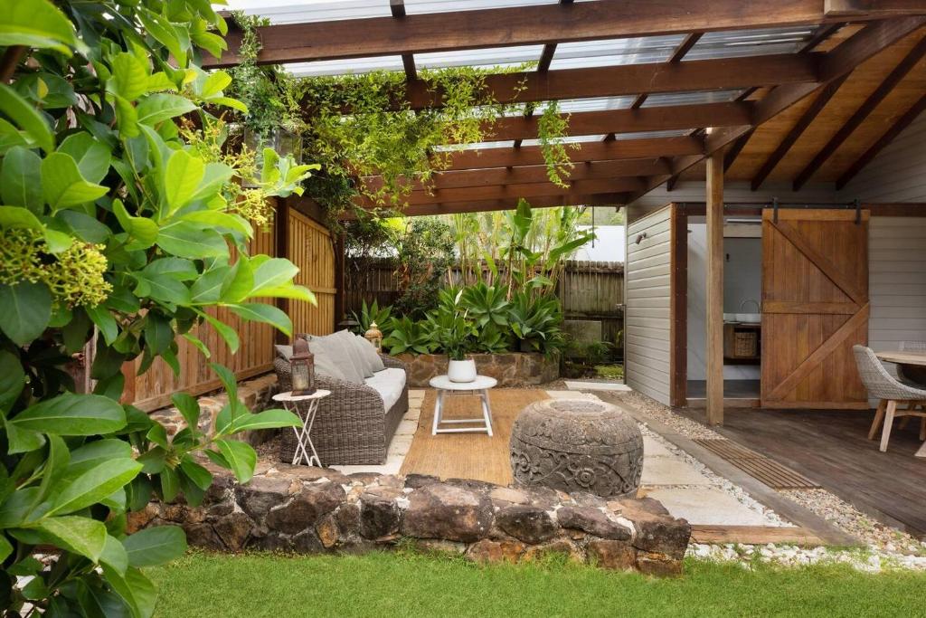 a garden with a pergola and a table and chairs at Mini Mullum Studio Retreat in Mullumbimby