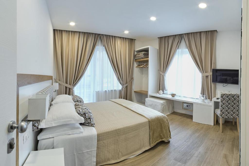 Dormitorio con cama, escritorio y TV en Dea Guest House, en Sorrento