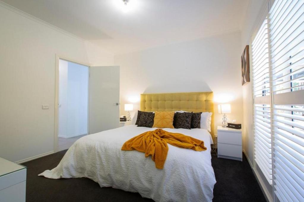 a bedroom with a bed with a yellow blanket on it at Relax and Unwind with Private Hot Tub in Rosebud in Rosebud