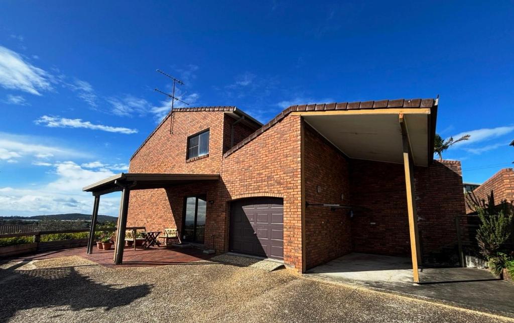 a brick house with a garage and a blue sky at Seaview Townhouse 2 - Bring your own linen. in South West Rocks
