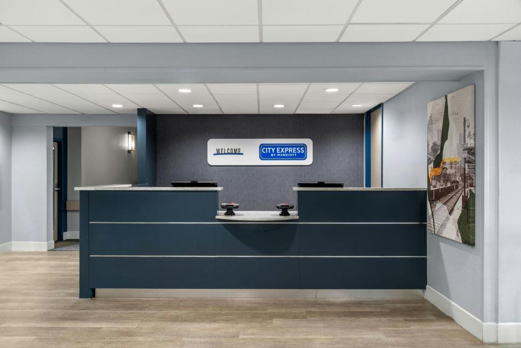 an office lobby with a reception desk and a sign at City Express By Marriott Findlay in Findlay
