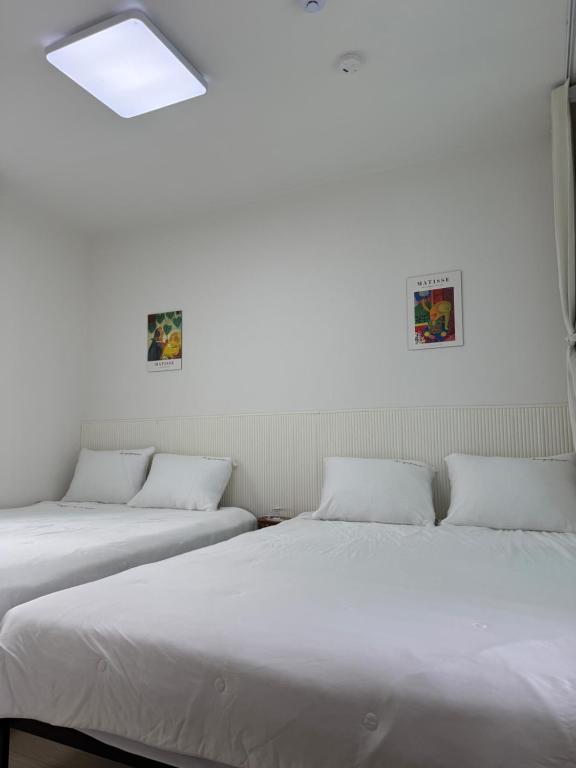 two beds are lined up in a room with white walls at 1&2 Stay in Daegu