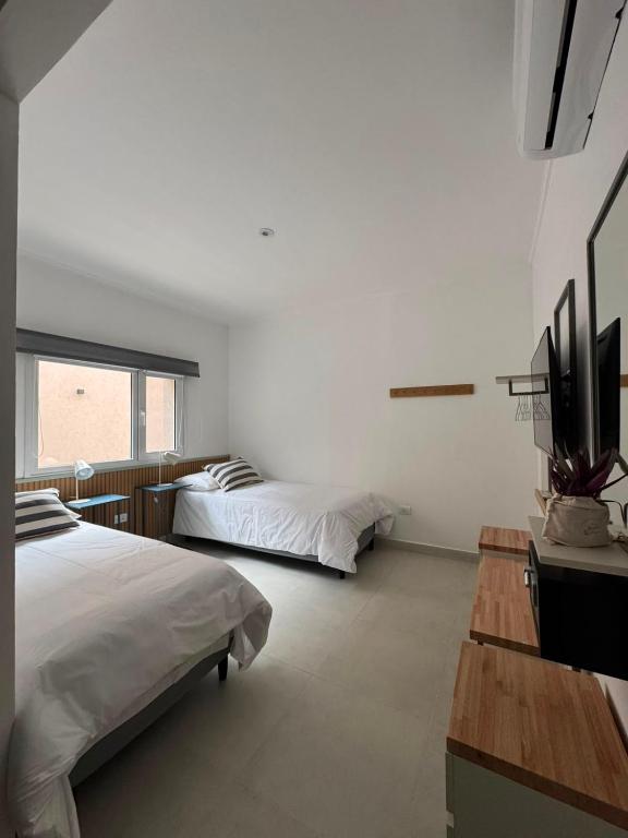 a bedroom with two beds and a flat screen tv at Entre Patios in Azul