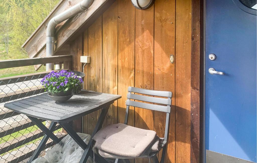 a table and a chair sitting on a deck at Nice Apartment In Rysstad With Wifi in Rysstad