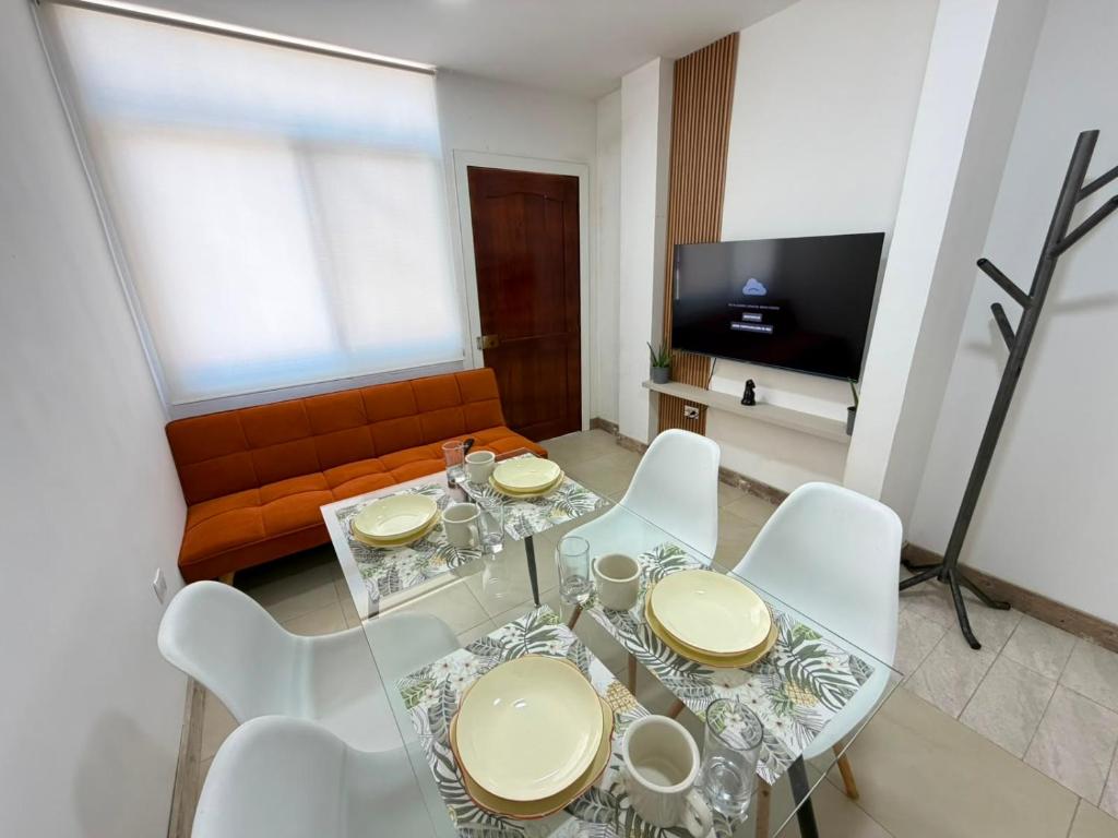 a living room with a glass table and white chairs at Departamento en Manta amoblado con seguridad privada in Manta