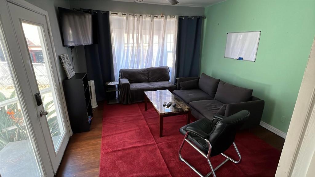 a living room with a couch and chairs and a table at Journey House LA in Los Angeles