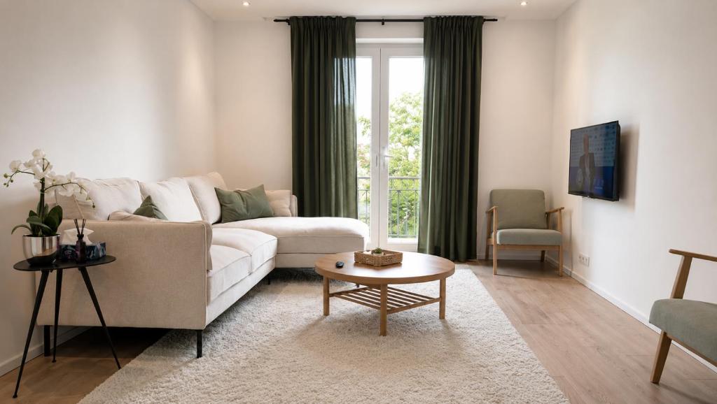 a living room with a white couch and a table at Élégant stays in Vilvoorde