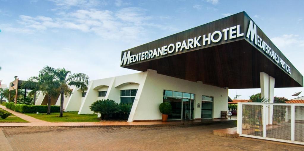a white building with a sign on top of it at Mediterrâneo Park Hotel in Três Lagoas