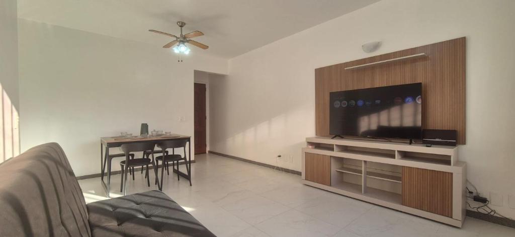 a living room with a flat screen tv and a table at Praia do Forte - AP DA PAZ in Cabo Frio
