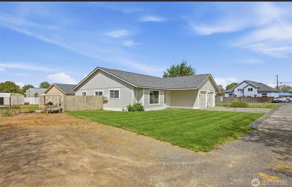 a large white house with a yard at Central Comfort Duplex in Moses Lake