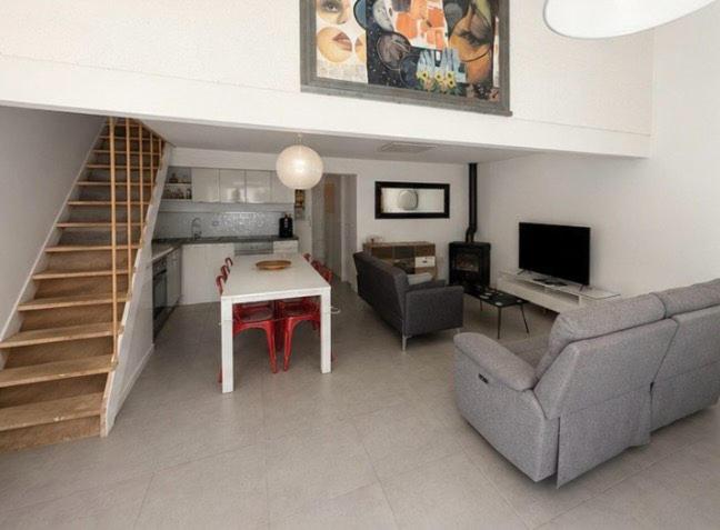 a living room with a couch and a table and a staircase at Cité château de Carcassonne in Berriac