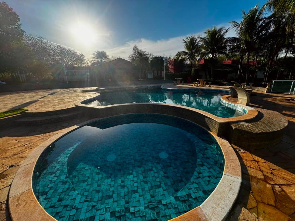 a swimming pool with blue water in a resort at Hotel Fazenda Haras RD in Olímpia