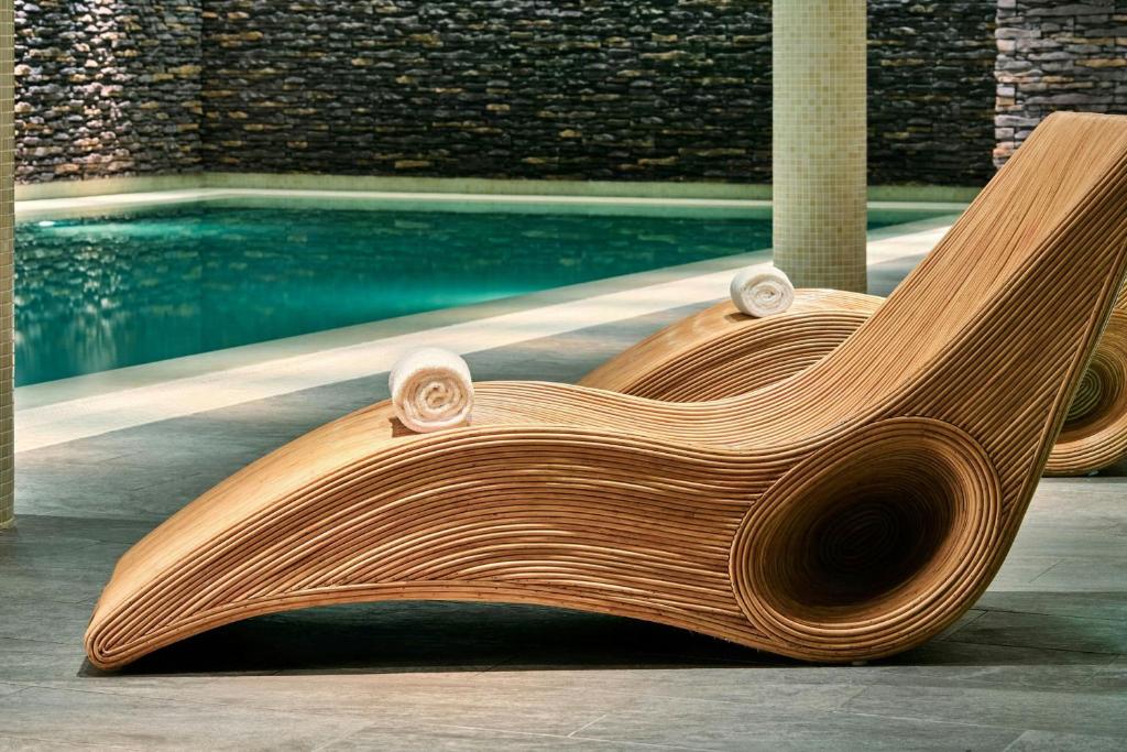 a wooden bench next to a swimming pool at AC Hotel by Marriott Wroclaw in Wrocław