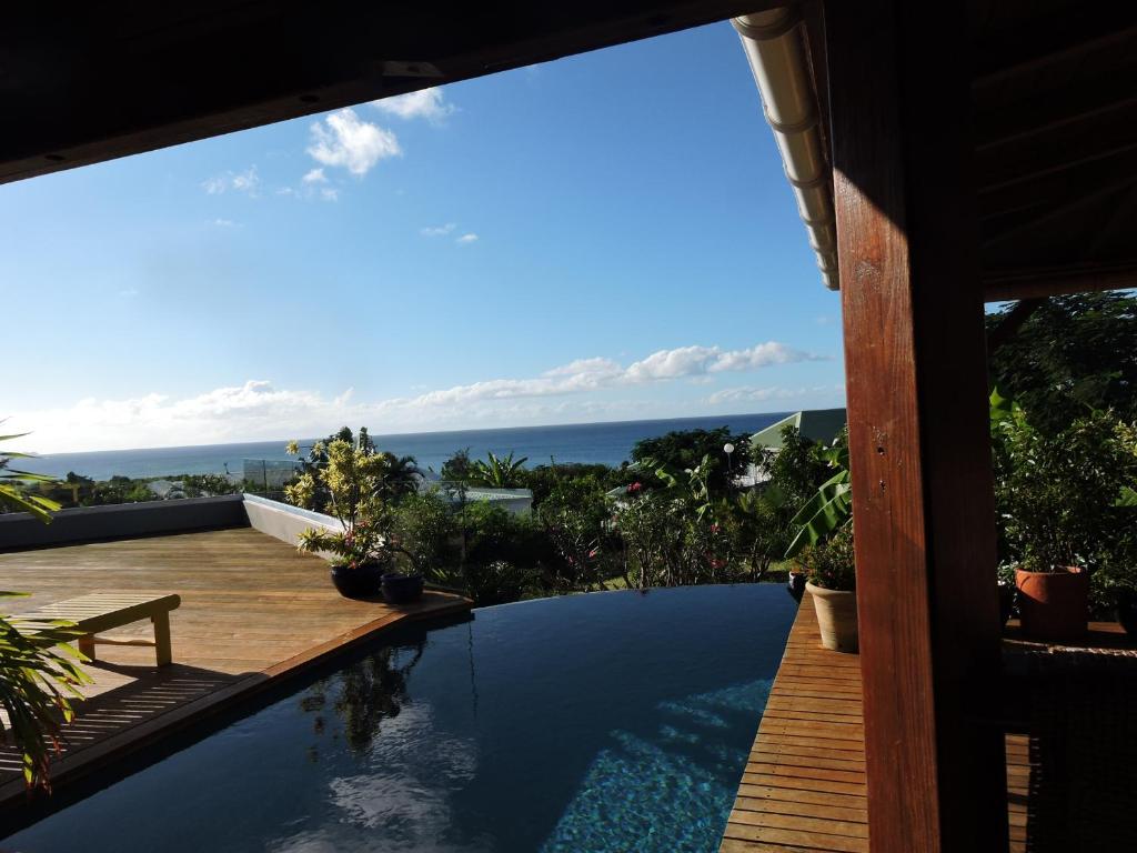 uma vista para o oceano a partir de uma casa com piscina em villa Colibri em São Martinho